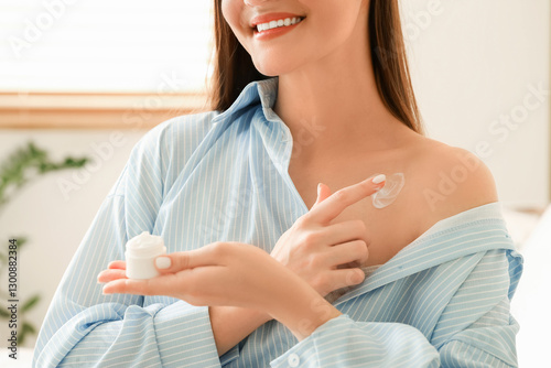 Young woman applying cream ...