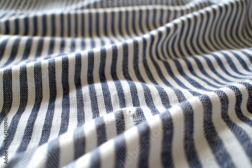 Blue and White Striped Fabric: A close-up view of a fabric with a repeating pattern of blue and white stripes, showcasing its texture and folds, evoking a sense of simplicity and classic style.