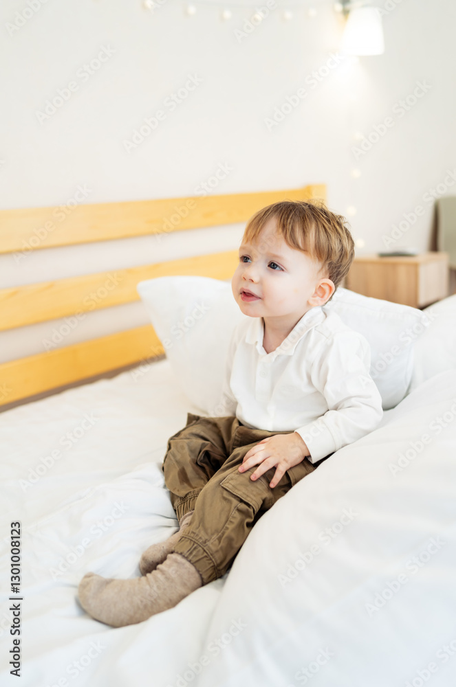 Toddler playfully on bed. A young child sits on a cozy bed, looking curious and playful in a bright and inviting bedroom. Toddler playfully on bed. A young child sits on a cozy bed, looking curious and playful in a bright and inviting bedroom.