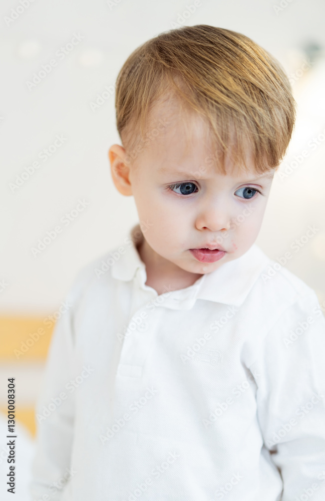 Light-haired boy in bright room. A young boy stands in a softly lit room, showing curiosity with a thoughtful expression on his face. Light-haired boy in bright room. A young boy stands in a softly lit room, showing curiosity with a thoughtful expression on his face.