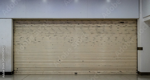 A shop that has closed down and is shuttered up in a shopping mall depicting the downturn in the British economy.