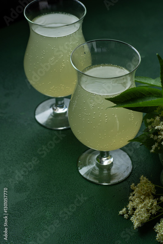 Carbonated elderflower drink. Flower summer kvass in glasses. Sparkling homemade hugo yellow water.