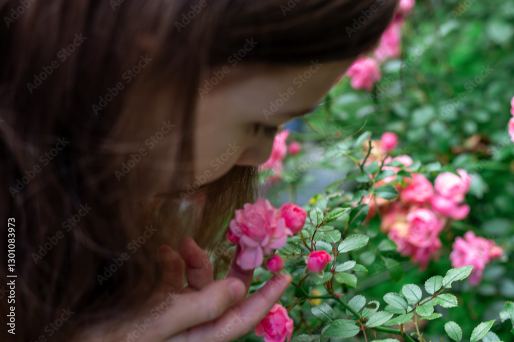 Fototapeta premium Cute child girl smelling flower