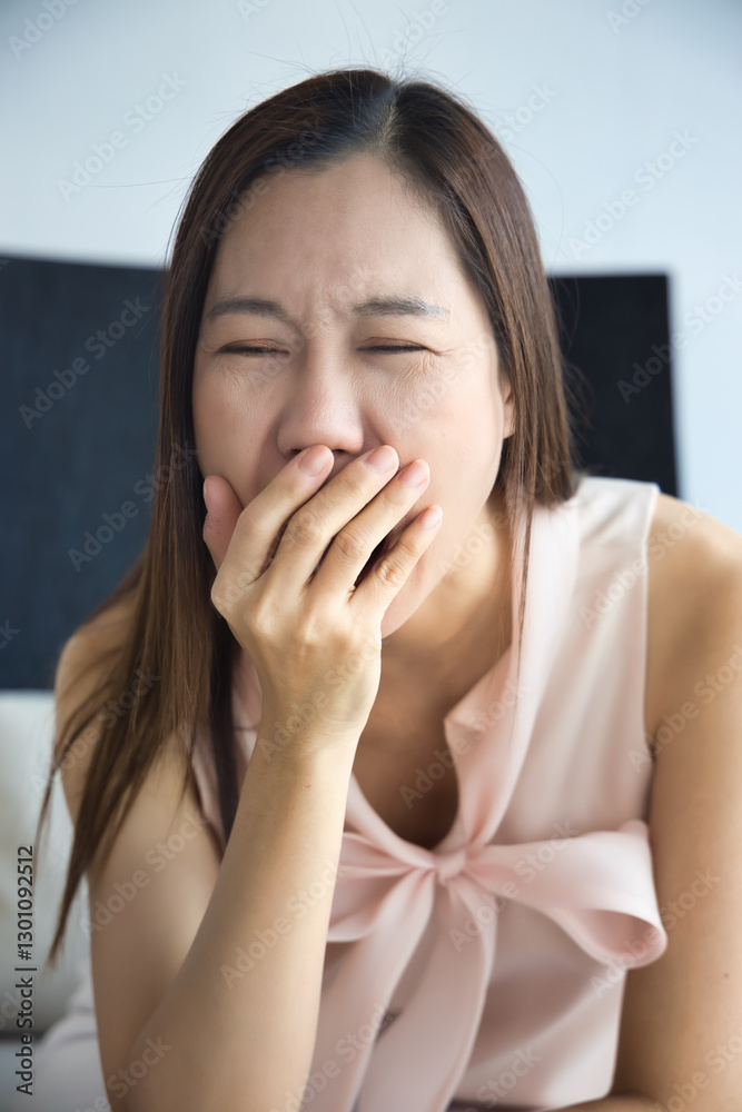Tired and sleepy middle aged asian woman yawning from overwork, stress, insomnia, brain fog, vitamin or nutrition deficiency concept image Tired and sleepy middle aged asian woman yawning from overwork, stress, insomnia, brain fog, vitamin or nutrition deficiency concept image