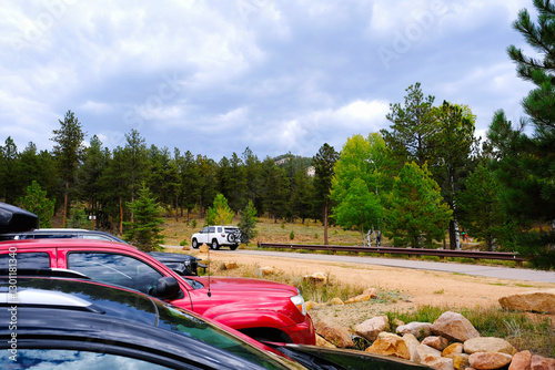 Fototapeta Naklejka Na Ścianę i Meble -  Cars parked near a forested area of a nature park.