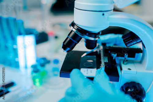 Microscope is being used to examine a sample. The microscope is blue and white.