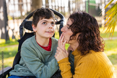 child with disability playing with mother in wheelchair at park