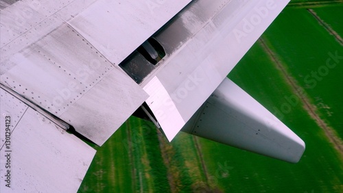 Obraz na plátně Airplane wing with flaps and spoilers extended during takeoff, flying over the g