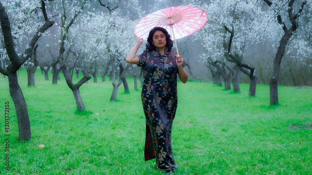 Young woman wearing traditional chinese dress walking in almond orchard