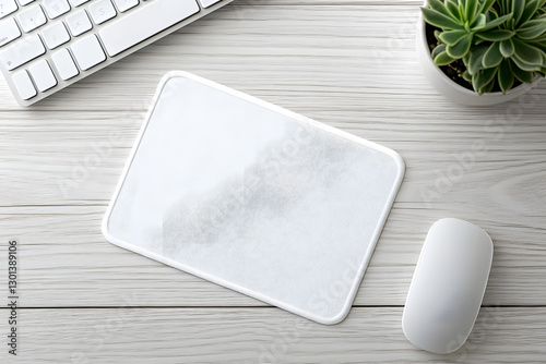 A minimalist mousepad mockup showcasing a pad, mouse, keyboard, and a succulent plant on a white wooden office desk, a contemporary minimal workspace template for your product or design, top view