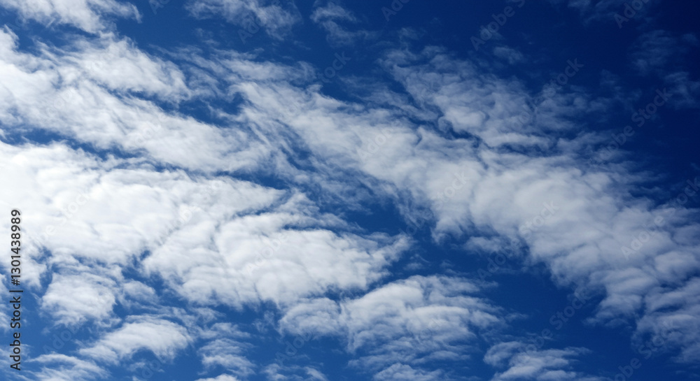 Fototapeta premium Dramatic sky with wispy white clouds on a blue backdrop