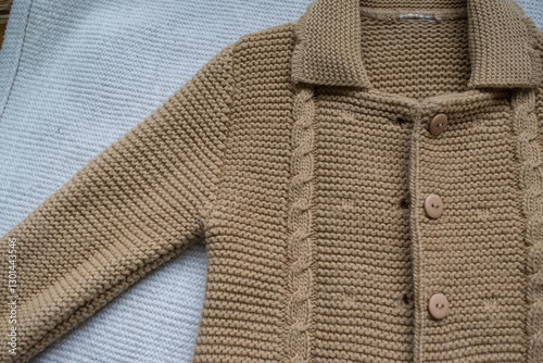 knitted baby sweater on white background
