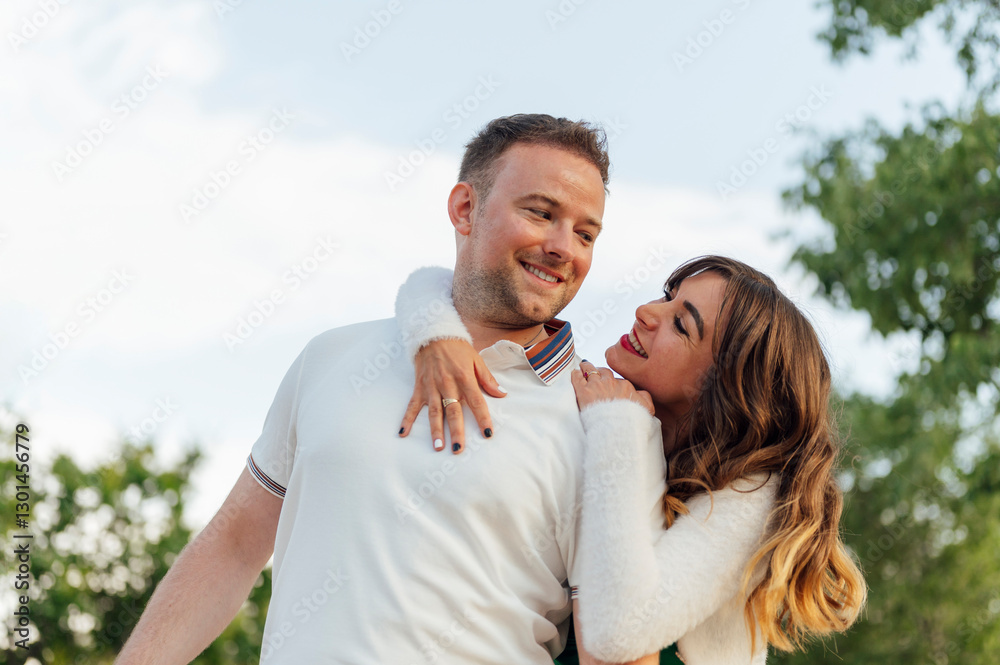 Happy couple embracing and smiling in a park Happy couple embracing and smiling in a park