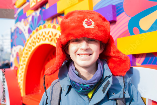  Teenage boy in a Russian red ushanka hat with the USSR coat of arms on the hat. At the traditional holiday 