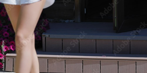 legs of a beautiful girl going down the stairs to the backyard