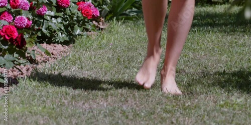 beautiful girl walks barefoot on the grass

