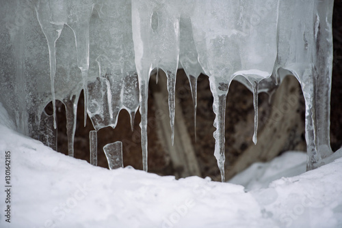 A detailed close-up of icicles hanging from a frozen surface, showcasing intricate ice formations and the beauty of winter nature.  

