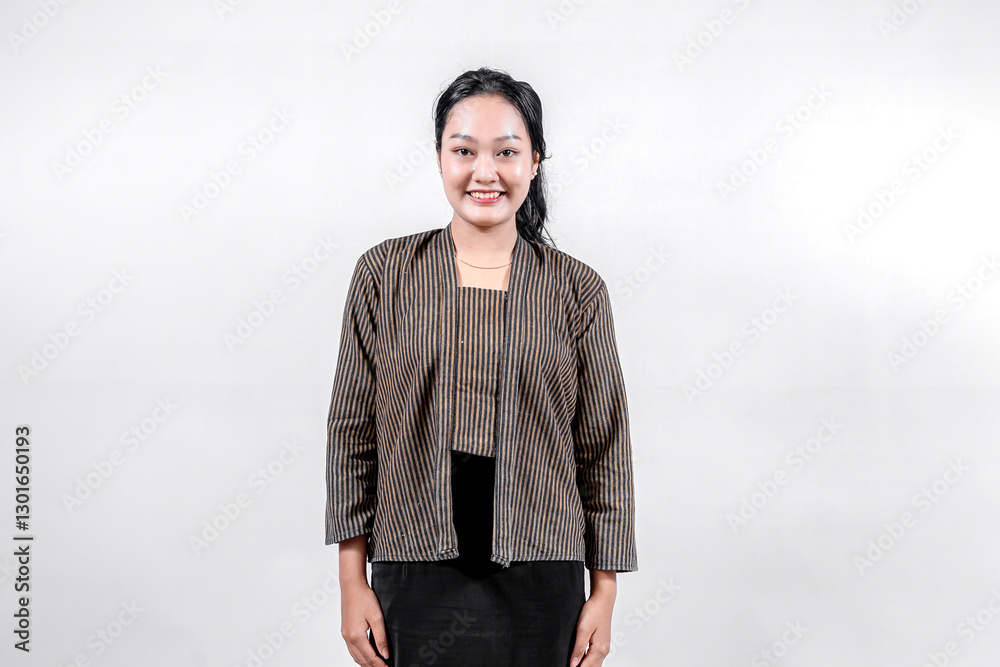 An Indonesian woman wearing traditional lurik attire smiles warmly at the camera, showcasing her cultural pride and elegance against a neutral background An Indonesian woman wearing traditional lurik attire smiles warmly at the camera, showcasing her cultural pride and elegance against a neutral background