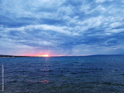 Dramatic seascape at sunset with stormy clouds and glowing horizon