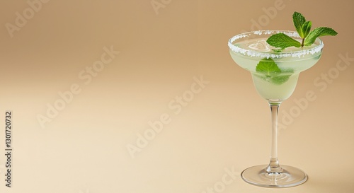 Margarita cocktail with fresh mint leaves and ice in a stylish glass against a warm beige background photo