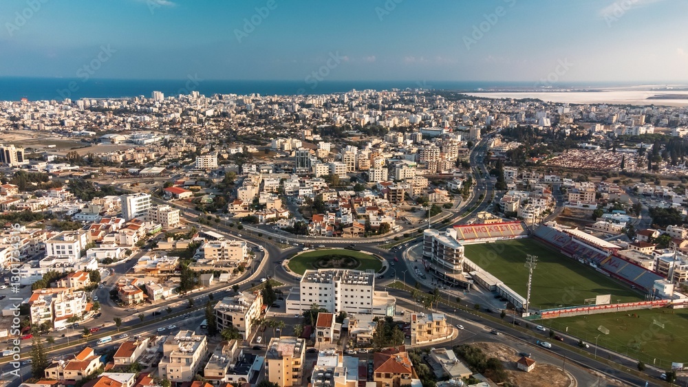 Fototapeta premium Aerial view of Larnaca, Cyprus, showcasing the cityscape, coastline, and a football stadium.