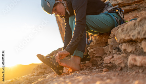 Slika na platnu A young girl puts on special climbing shoes on her legs before climbing outdoor training, hands and feet close-up