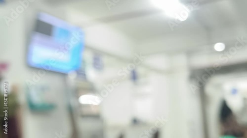 A deliberately blurry and soft focus image capturing the essence of a public waiting area, focusing on abstract shapes and subtle gradations of light and shadow. Evokes a feeling of transience.
