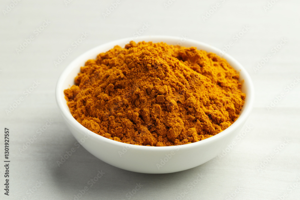 Turmeric powder in bowl on white table, closeup Turmeric powder in bowl on white table, closeup