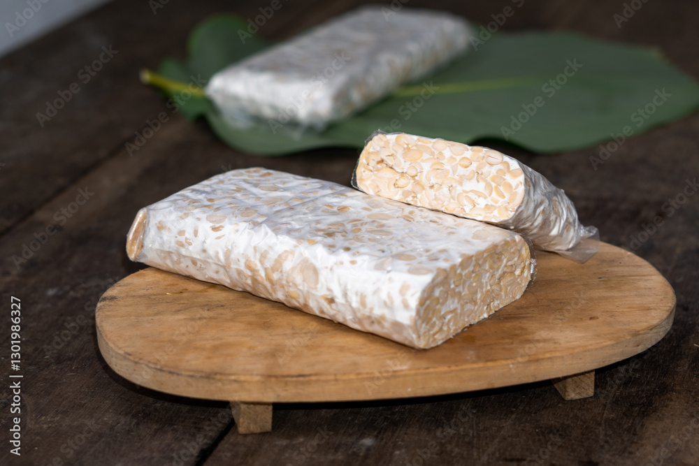 Raw Tempeh Slices on Wooden Board Background. Tempeh is Made from Fermented Soybeans Raw Tempeh Slices on Wooden Board Background. Tempeh is Made from Fermented Soybeans
