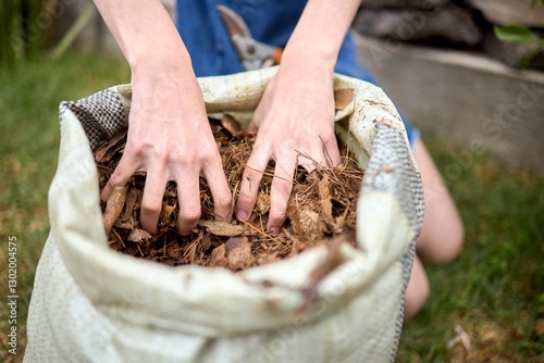 Hands handling dried leaves for composting