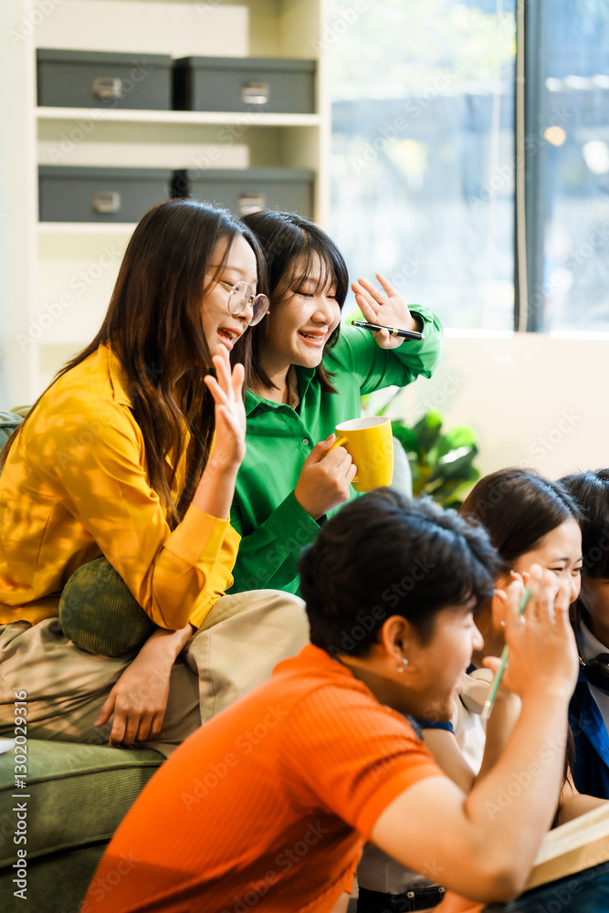 A group of young Asian college friends sitting on a sofa at home, watching a laptop, enjoying cheerful conversation and laughter, bonding over friendship, and sharing happy experiences together A group of young Asian college friends sitting on a sofa at home, watching a laptop, enjoying cheerful conversation and laughter, bonding over friendship, and sharing happy experiences together