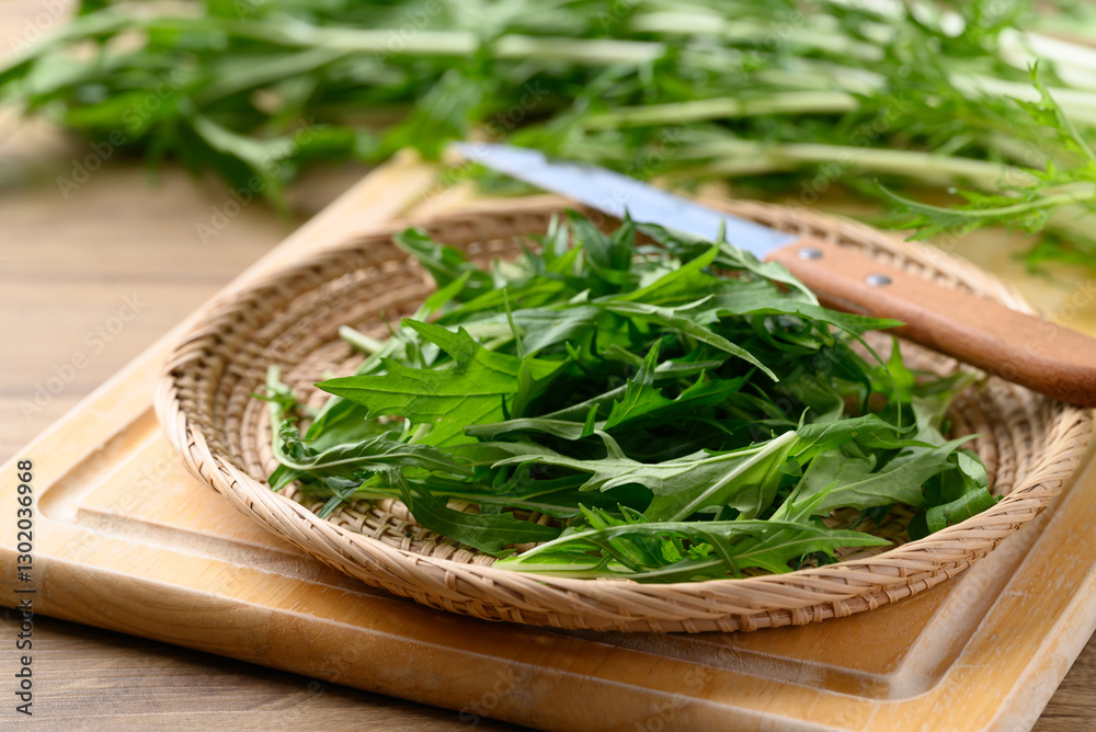 Mizuna, Water green, Japanese mustard green or spider mustard in basket on cutting wooden board Mizuna, Water green, Japanese mustard green or spider mustard in basket on cutting wooden board