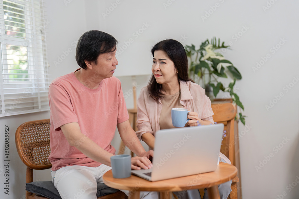 Older couple discussing online activities while enjoying coffee at home. Older couple discussing online activities while enjoying coffee at home.