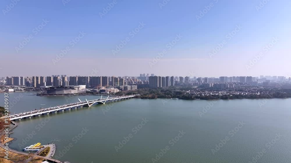 Aerial views of Wuxi Li Lake Bridge showcasing urban landscape and serene waters Aerial views of Wuxi Li Lake Bridge showcasing urban landscape and serene waters