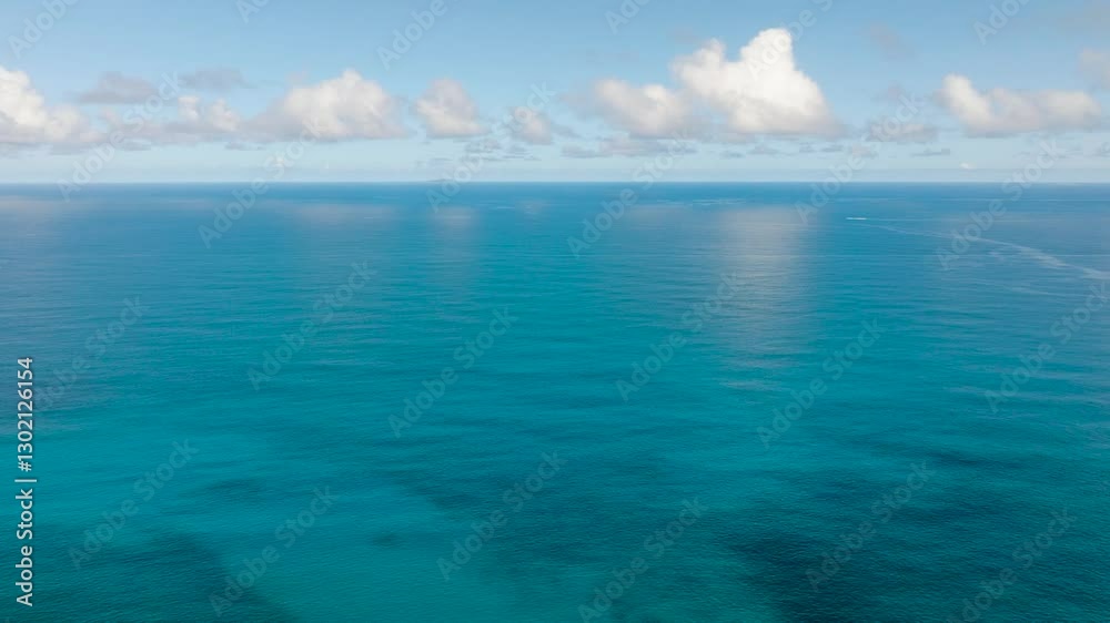 A serene view of endless blue ocean waters reflecting the sky, with soft clouds floating above. A serene view of endless blue ocean waters reflecting the sky, with soft clouds floating above.