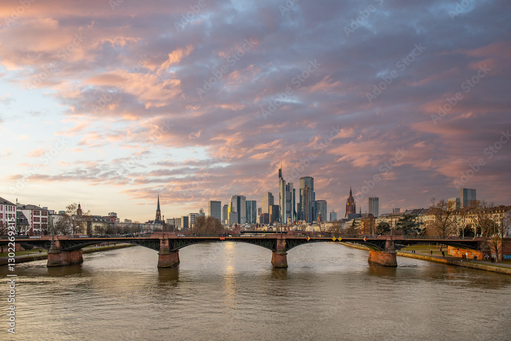 View from a Main Bridge of a skyline in the financial district in the background as the sun sets. Twilight in Frankfurt am Main, Hesse Germany View from a Main Bridge of a skyline in the financial district in the background as the sun sets. Twilight in Frankfurt am Main, Hesse Germany