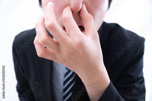 鼻を摘んで臭さに耐える男性