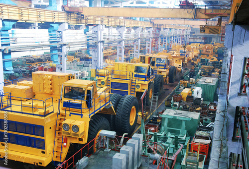 Assembly line of large dump trucks. Finished dump trucks are lined up in a production shop. No AI tools