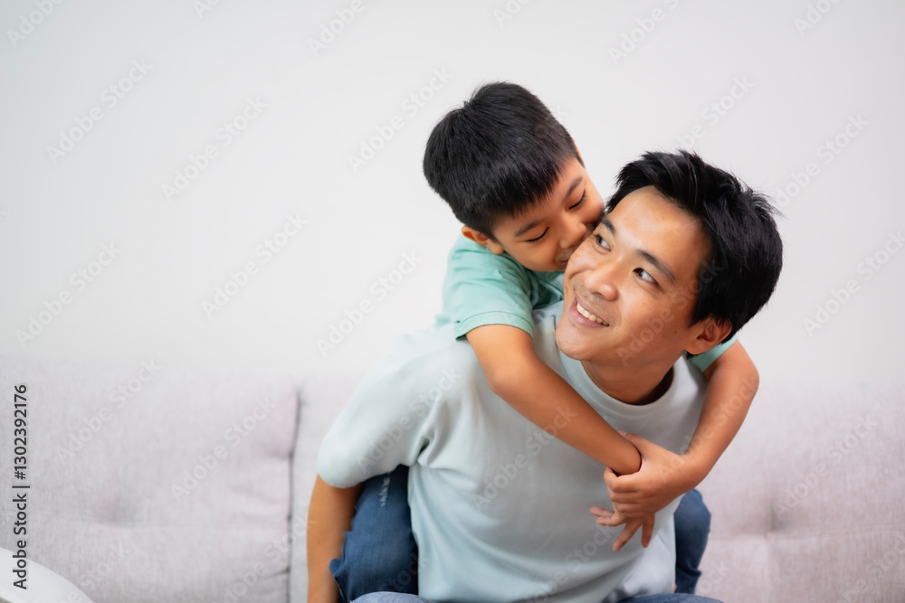 Portrait of boy on father's back, embrass him with love and smile. Happy and kind dad together at living room. Relationship, bonding in family with white background. Portrait of boy on father's back, embrass him with love and smile. Happy and kind dad together at living room. Relationship, bonding in family with white background.