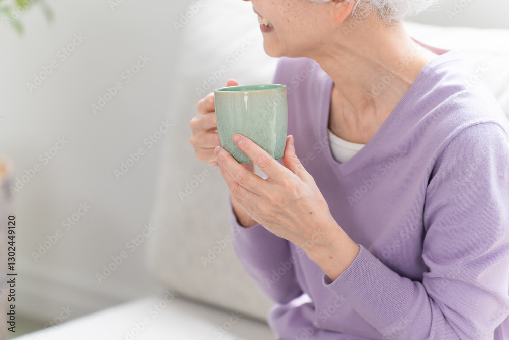 ソファーでコーヒーを飲みながらくつろぐシニア女性
ソファーでコーヒーを飲みながらくつろぐシニア女性