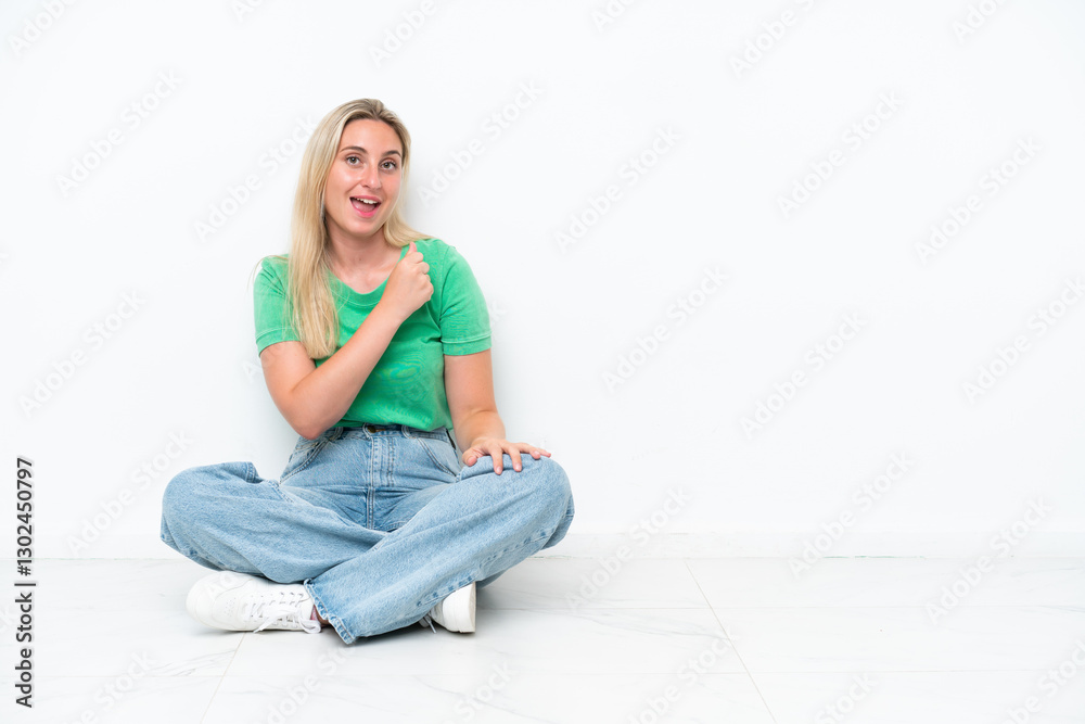 Young caucasian woman sitting on the floor isolated on white background celebrating a victory Young caucasian woman sitting on the floor isolated on white background celebrating a victory