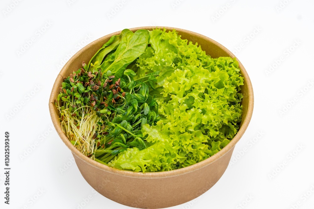 Fresh salad in a bowl on a white background. Close-up of fresh organic green salad with microgreens in a bowl. Healthy food. Fresh salad in a bowl on a white background. Close-up of fresh organic green salad with microgreens in a bowl. Healthy food.