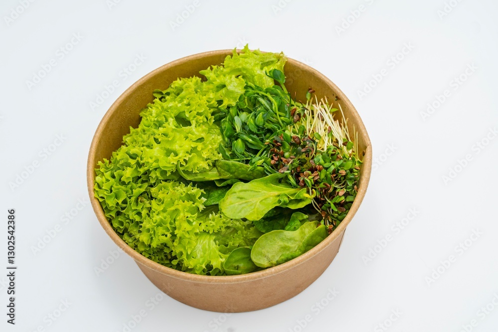 Fresh salad in a bowl on a white background. Close-up of fresh organic green salad with microgreens in a bowl. Healthy food. Fresh salad in a bowl on a white background. Close-up of fresh organic green salad with microgreens in a bowl. Healthy food.