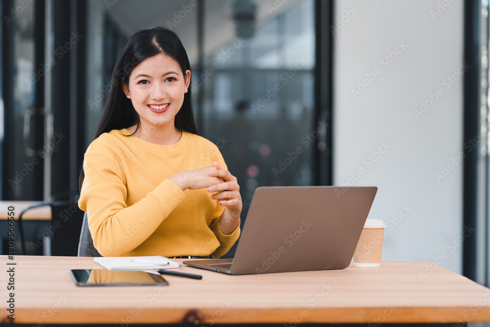 Asian businesswoman in yellow sweater writes on colorful sticky notes on glass wall, brainstorming ideas. Asian businesswoman in yellow sweater writes on colorful sticky notes on glass wall, brainstorming ideas.