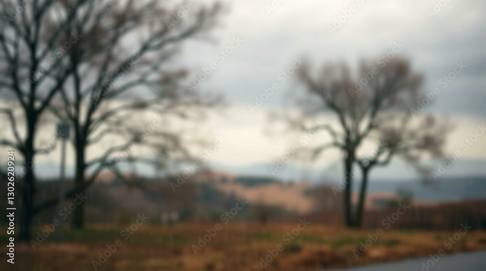 Blurred background of bare trees and golden hills under a cloudy sky, creating a serene and natural scene. Blurred background of bare trees and golden hills under a cloudy sky, creating a serene and natural scene.