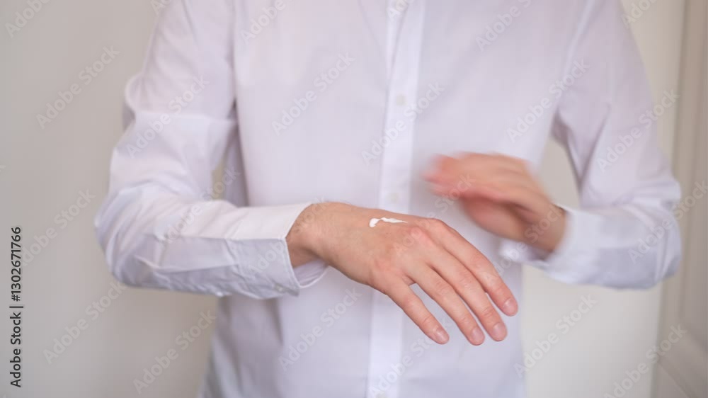 young man applying moisturizer to his hands close-up young man applying moisturizer to his hands close-up