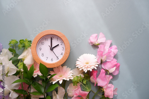 Obraz na płótnie Spring forward background. Beautiful flowers and a clock composition on pastel color background. Spring image and floral background. w salonie