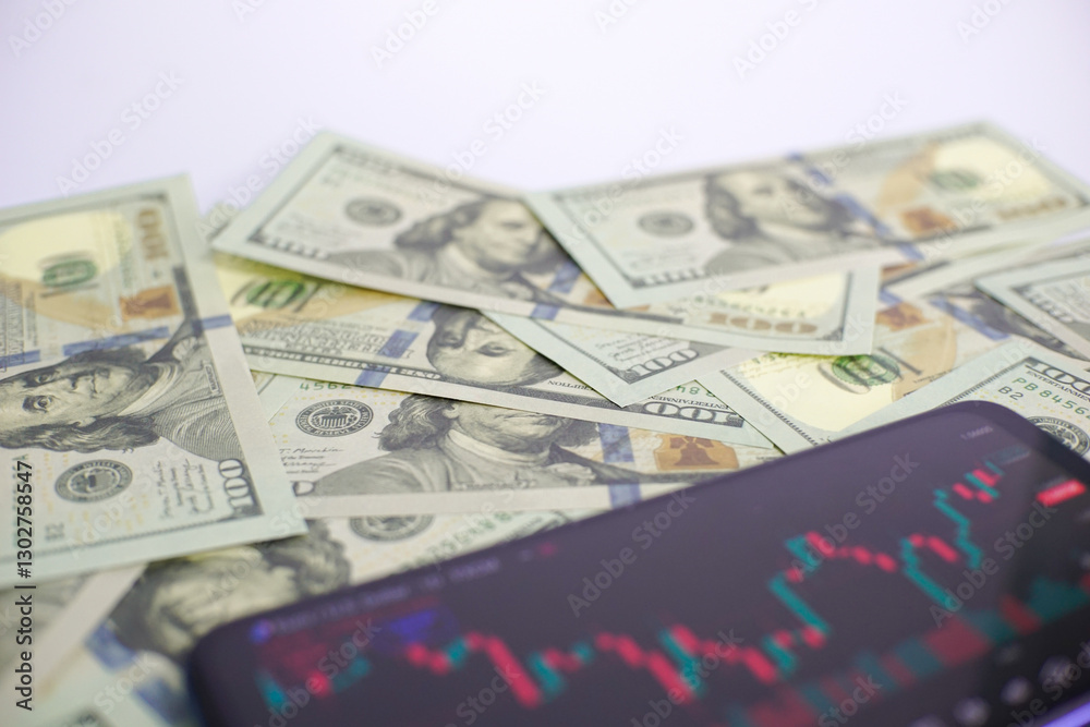 dollars and trading, the concept of trading via smartphone with a background of hundreds of US dollars, successful and failed trading, trading with a smartphone. dollars and trading, the concept of trading via smartphone with a background of hundreds of US dollars, successful and failed trading, trading with a smartphone.