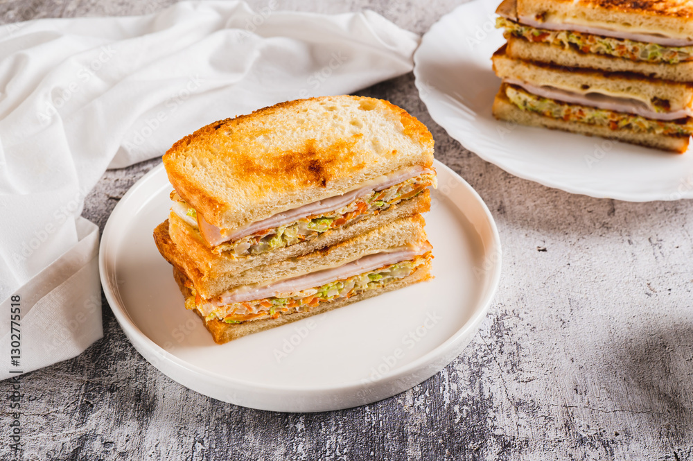 Korean street sandwich with cabbage, ham and cheese on plate on table