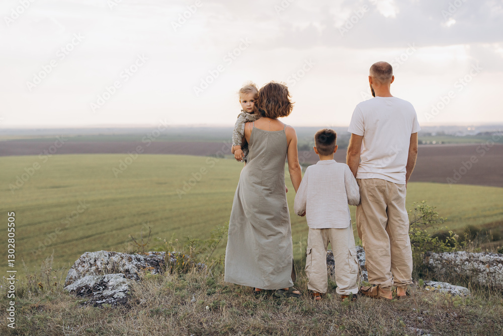 Family Enjoying Scenic View on a Rural Hilltop at Sunset Family Enjoying Scenic View on a Rural Hilltop at Sunset